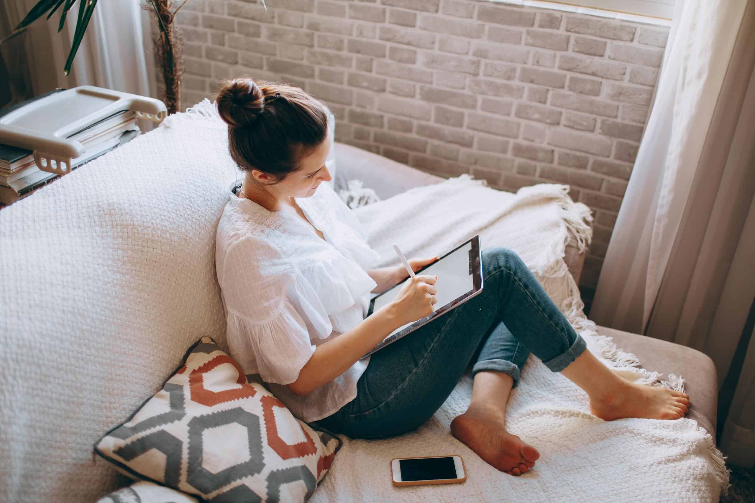 Young woman using tablet on couch