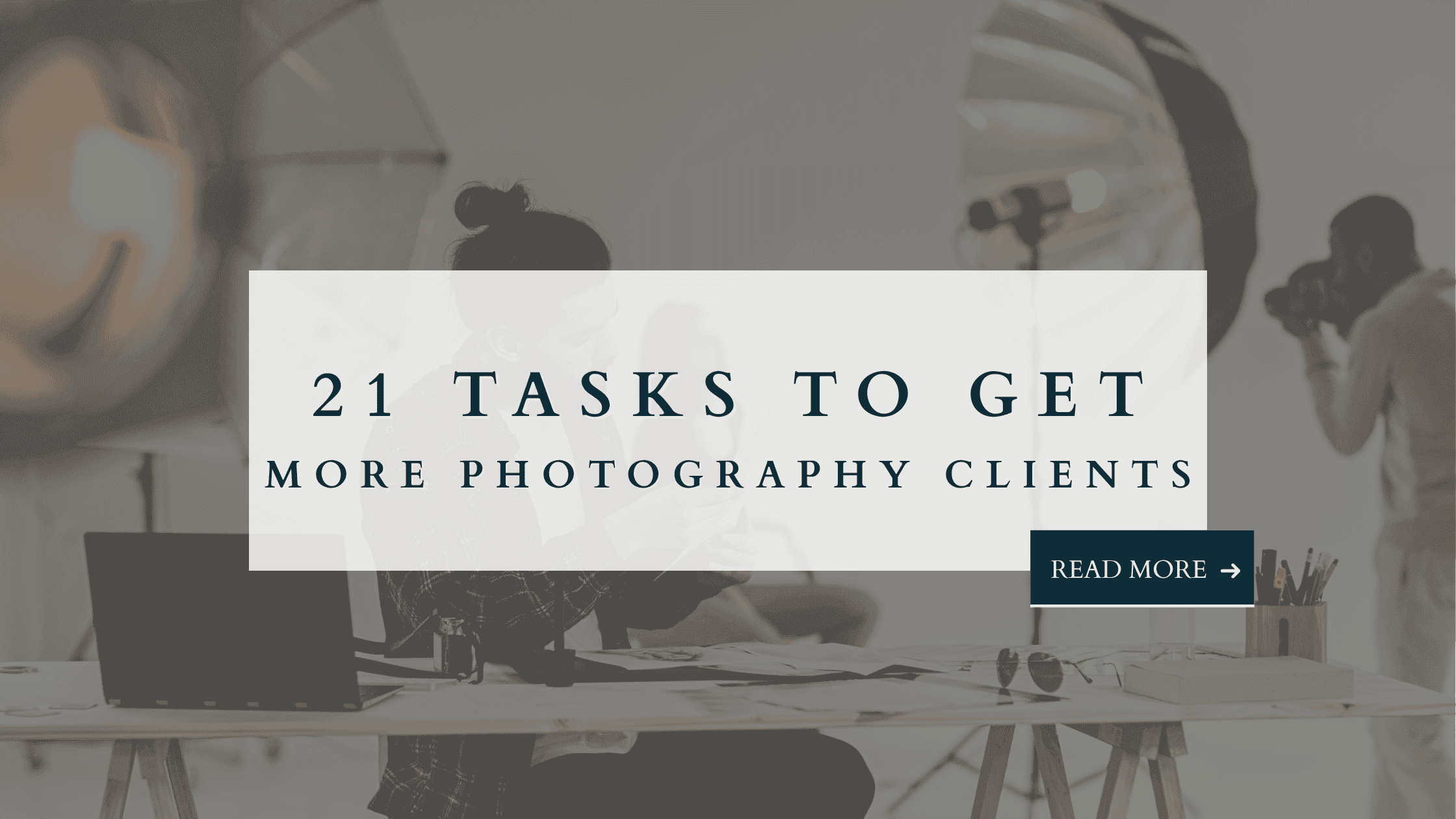 Photographer working in a studio with laptop and camera gear, text overlay: 21 Tasks to Get More Photography Clients.
